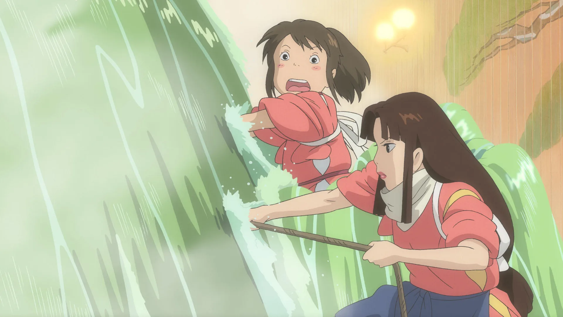 A still from the film Spirited Away showing Chihiro and her friend trying to fix a leak in a cascade of water - both look surprised and are wearing pink outfits.