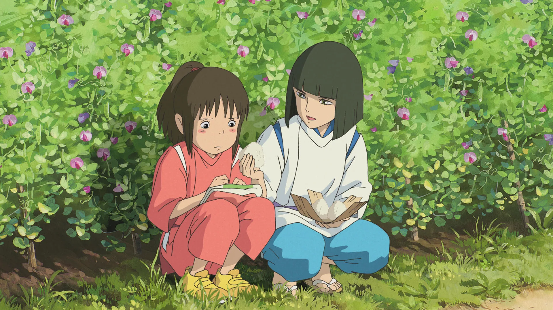 A still from Spirited Away showing Haku giving something to Chihiro against a bush