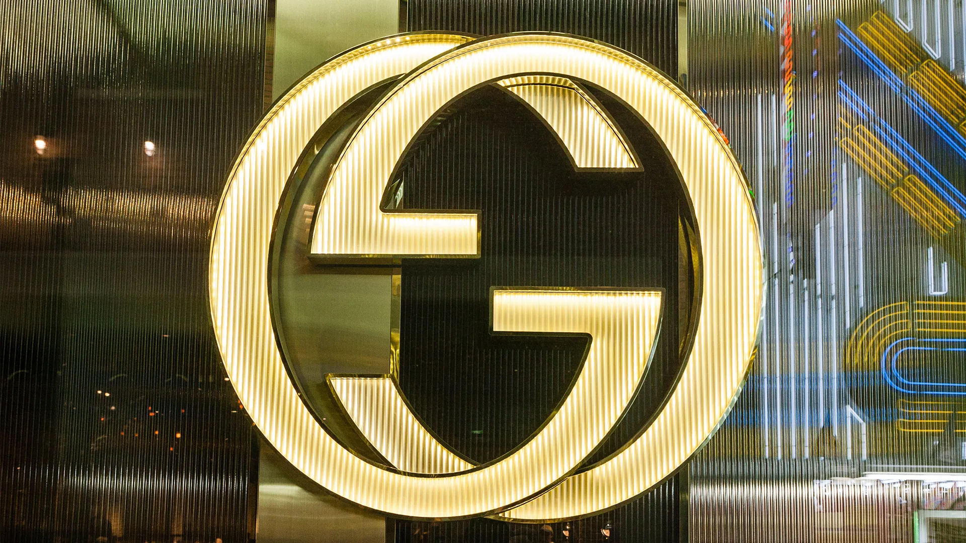 Gold Gucci logo on the side of a glass building