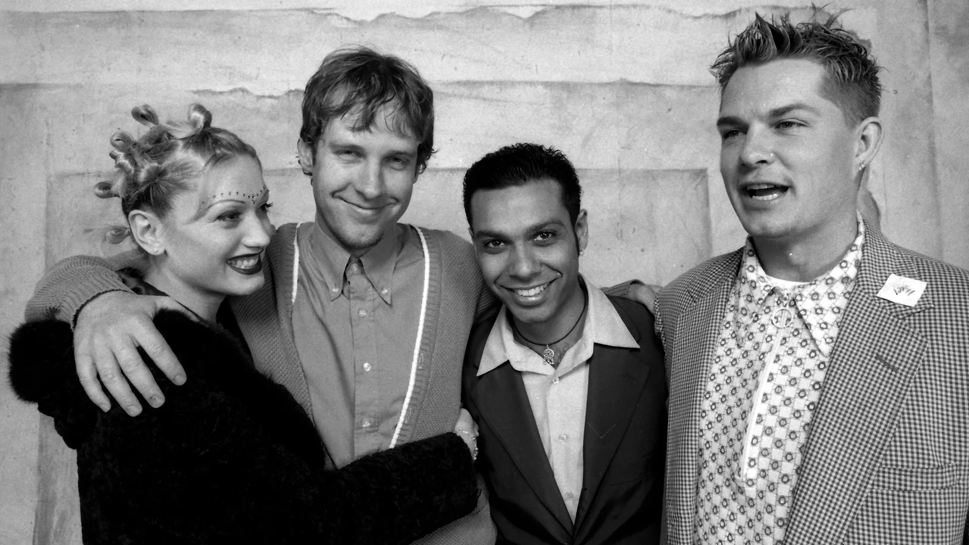A black and white photograph of the band No Doubt all hugging eachother