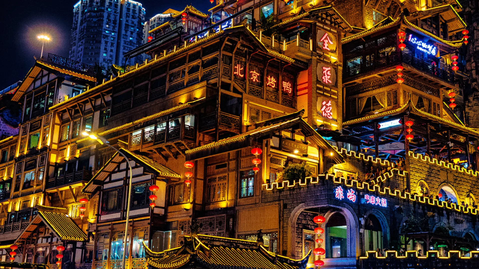 A photo of Chinese town scene lit up at night of buildings with lanterns