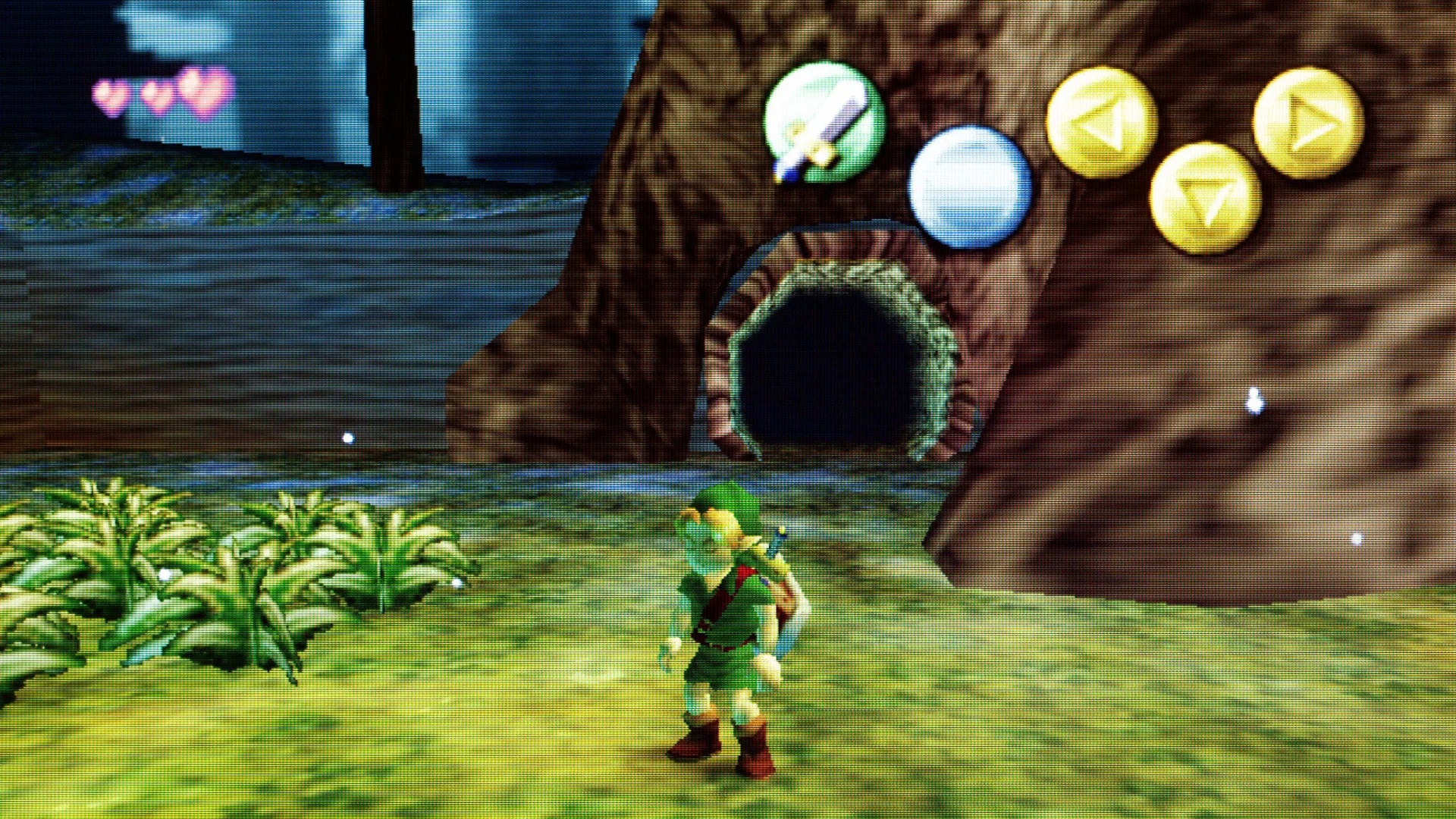 A scene from The Legend of Zelda: Majora's Mask showing Link stood in a green woodland with a tree behind him and energy orbs above. In the distance is a more gloomy wood.