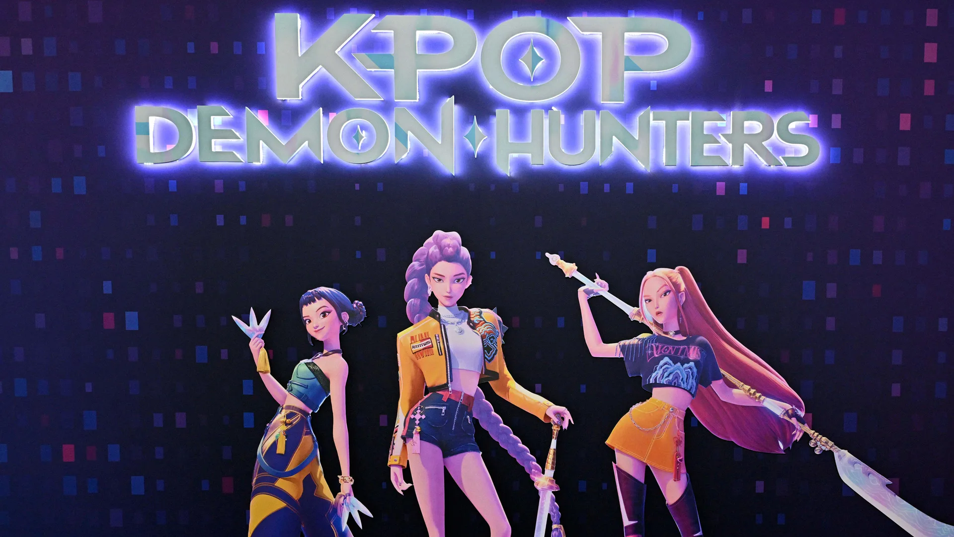 An image from KPop Demon Hunters showing the neon silver and purple logo for the movie and three of the characters stood below in different poses wearing colour coordinated yellow and blue outfits. They are stood against a black background.