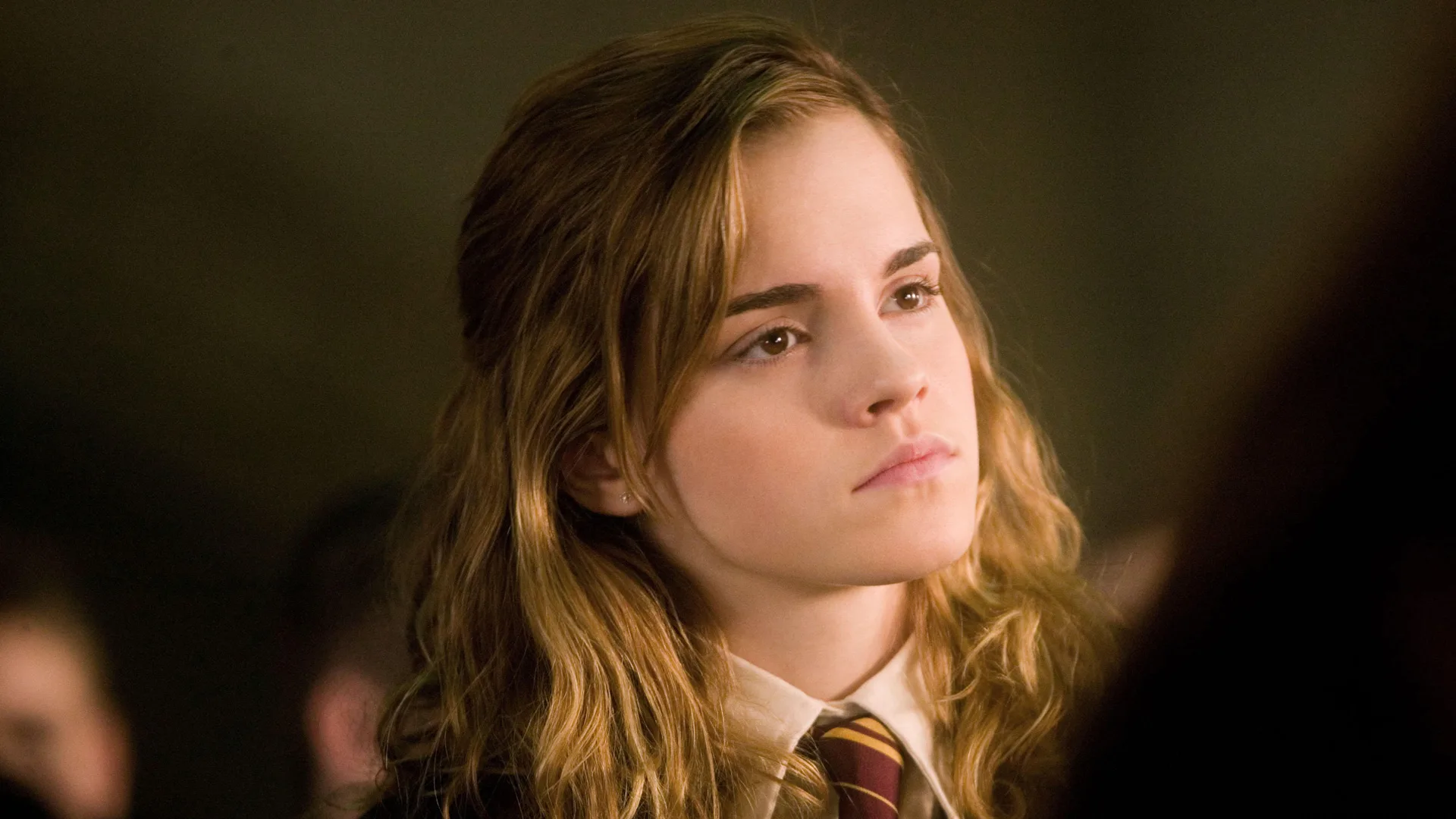 A still of Emma Watts playing Hermoine from the Harry Potter movie franchise. It is a close up of her face and she has a stern expression.