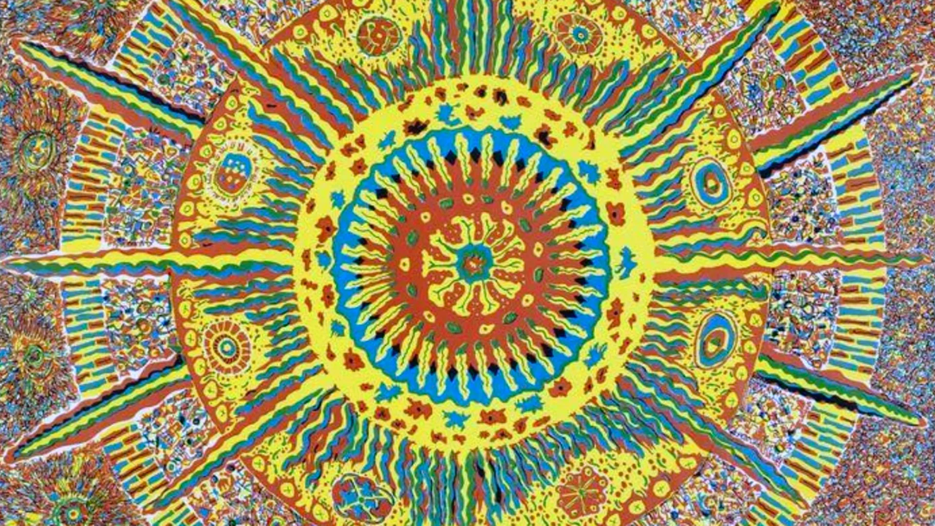 An image of a psychedelic pattern in circles and starbust formation in colours of yellows, blues and oranges.