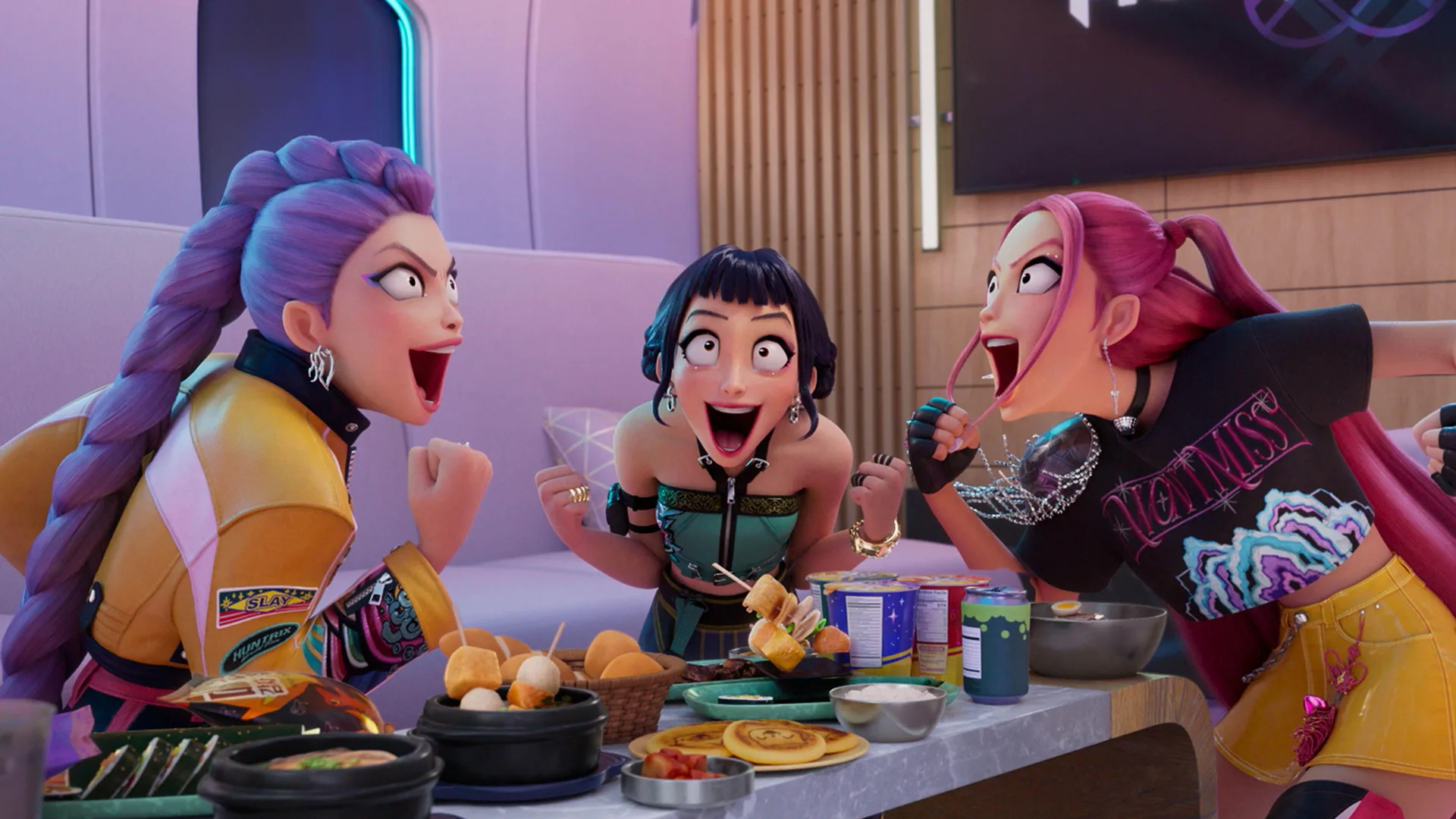 A still from Netflix's KPop Demon Hunters showing Rumi, Mira and Zoey screaming happily with a table full of food in a restaurant setting.