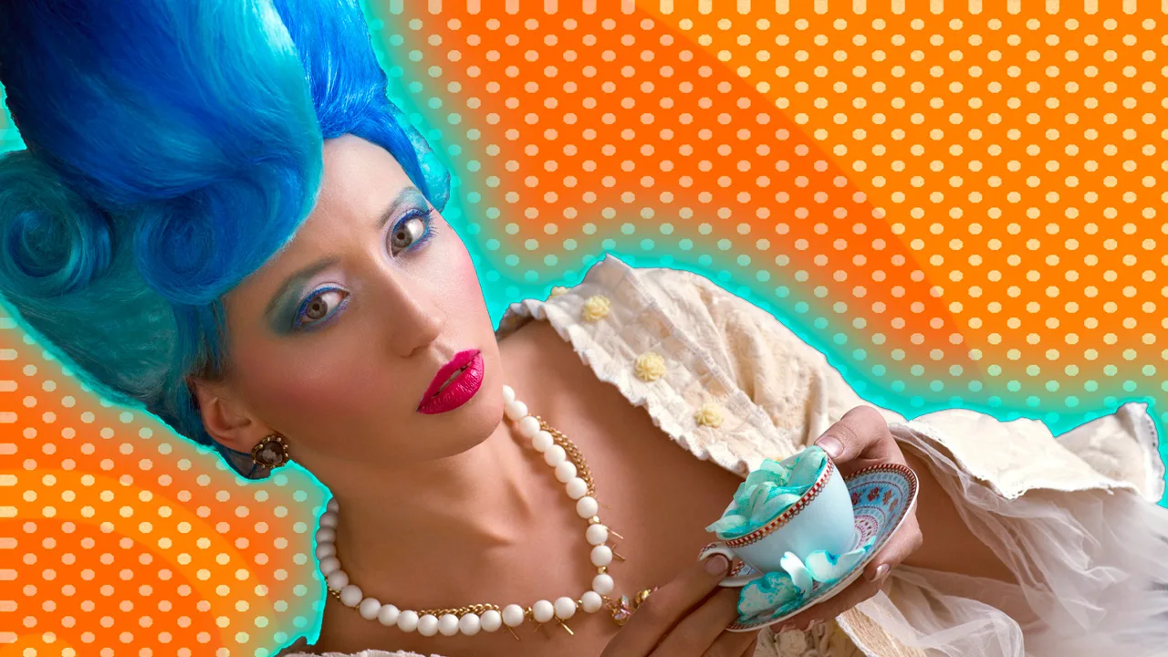 An image of a woman dressed in a blue rococo wig with a cream rococo dress and pearls on holding a blue cup and saucer against an orange dotted background.