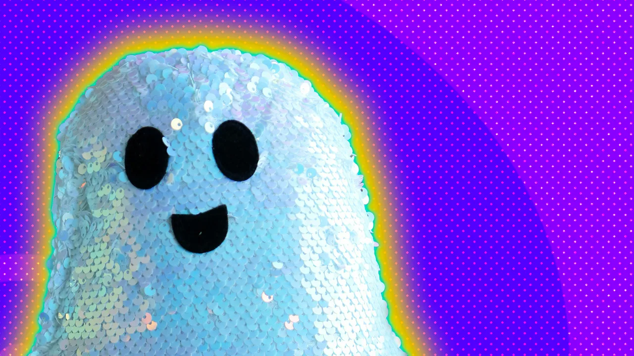 An image of a sequin ghost smiling with a purple dotted background and yellow and blue halo.