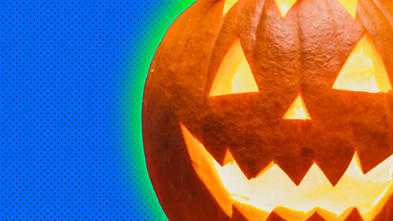 An image of a Halloween jack o lantern pumpkin with a smiling face carved into it set against a blue dotted background with a green halo.