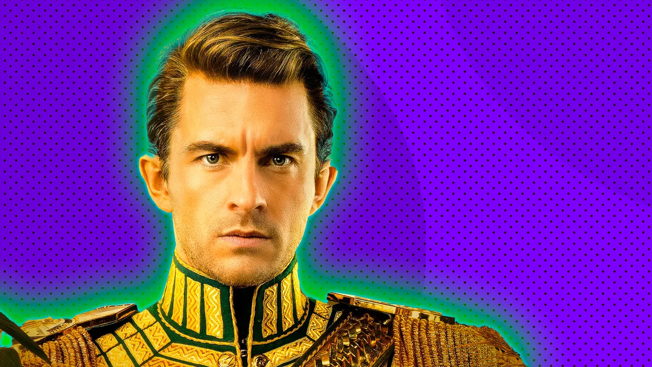 A still from the Wicked movie showing the Prince wearing gold staring directly ahead with a serious expression on his face set against a purple spotted background with a green halo.