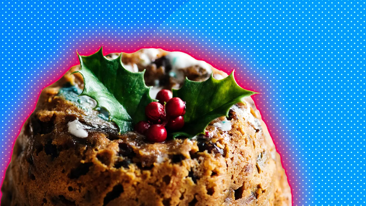A photo of a Christmas pudding with holly and berries on top set against a blue dotted background with red halo.