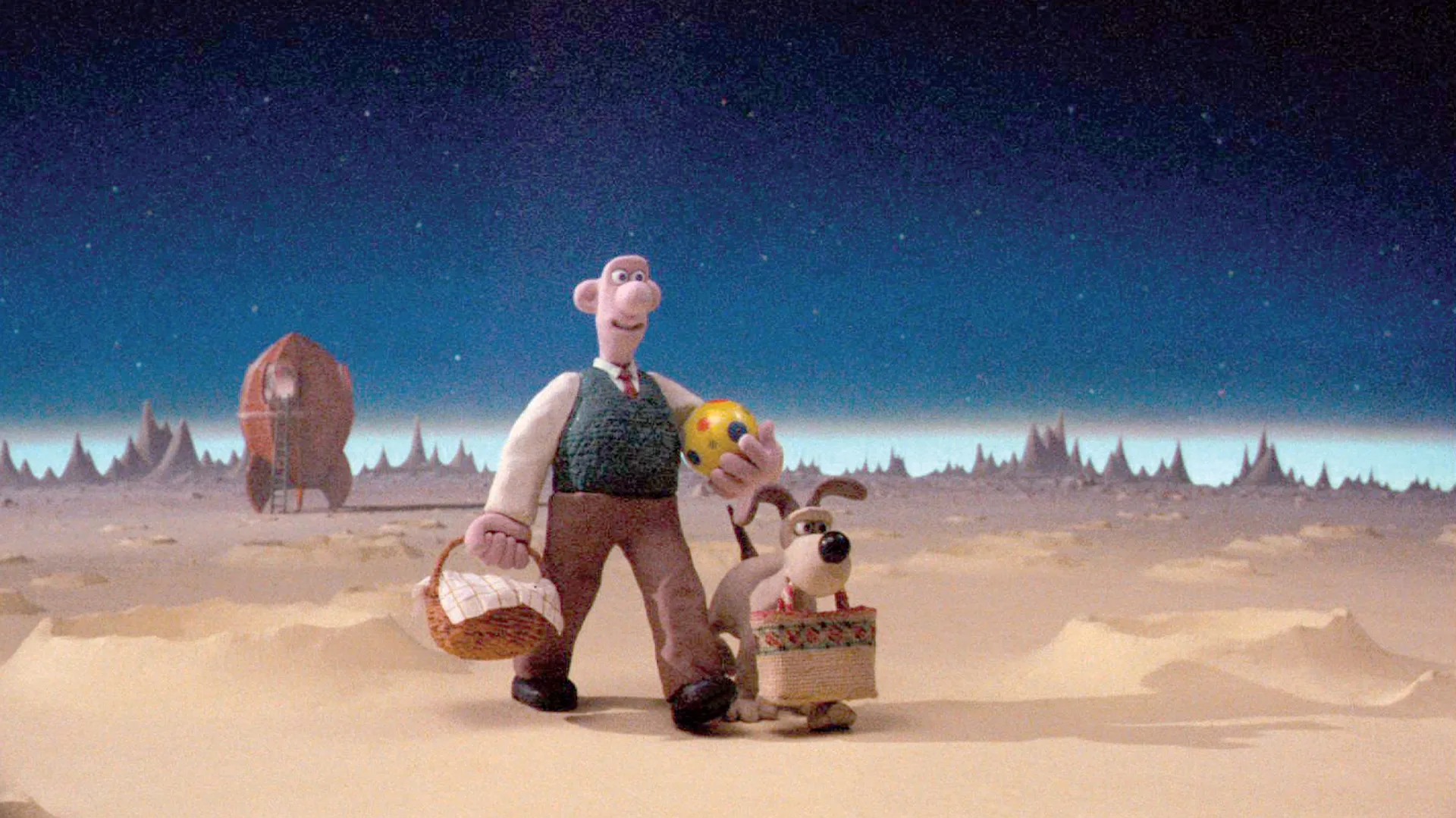 A still from Wallace and Gromit "A Grand Day Out" showing Wallace and Gromit walking on the moon holding picnic hampers and a ball to play with.