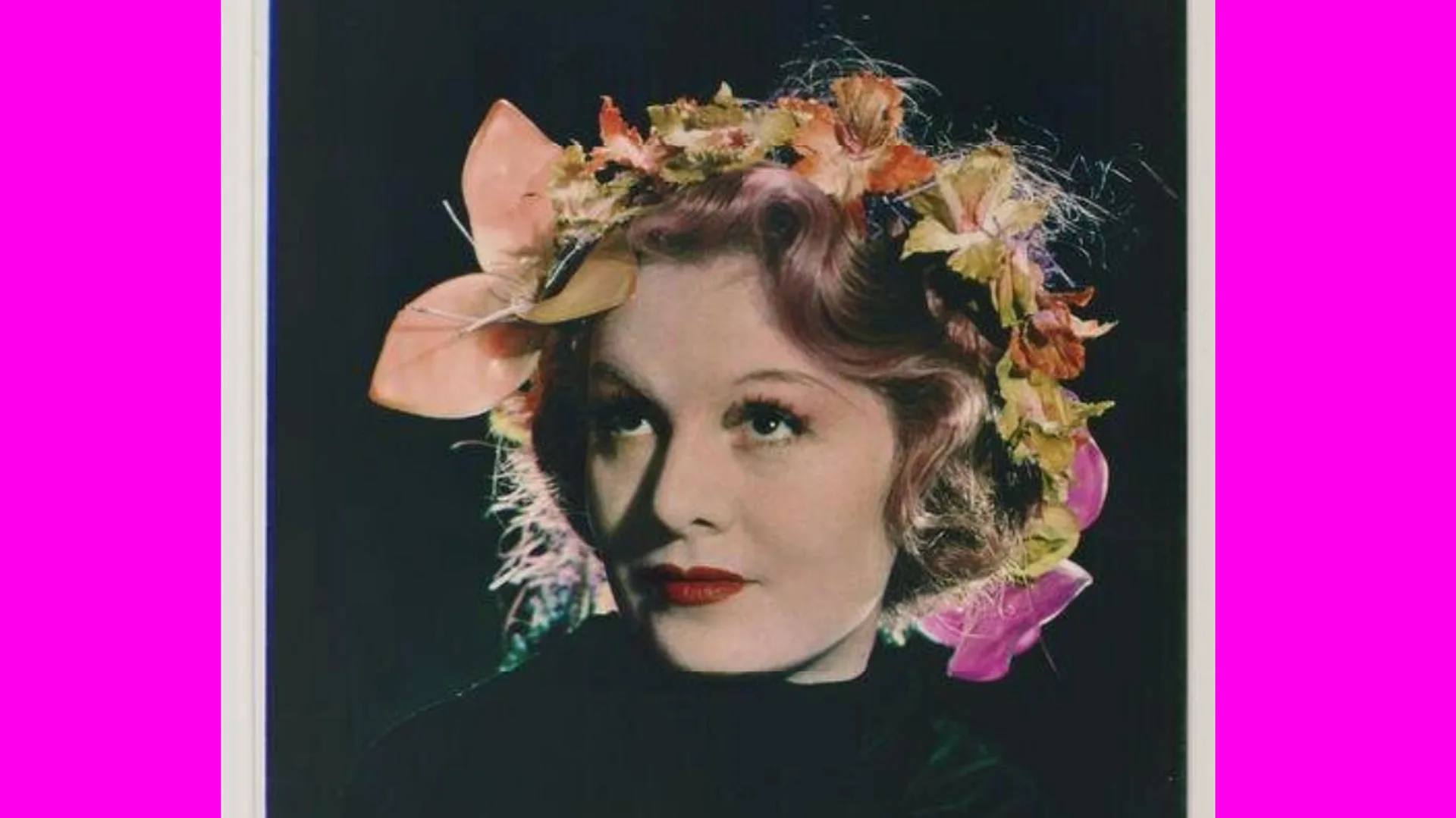 A photo taken by Yevonde of an actress Mrs Longdon as Persephone in the 1930s. She is wearing a floral crown and look up with a slight smile. She is set against a black background with neon pink borders either side.