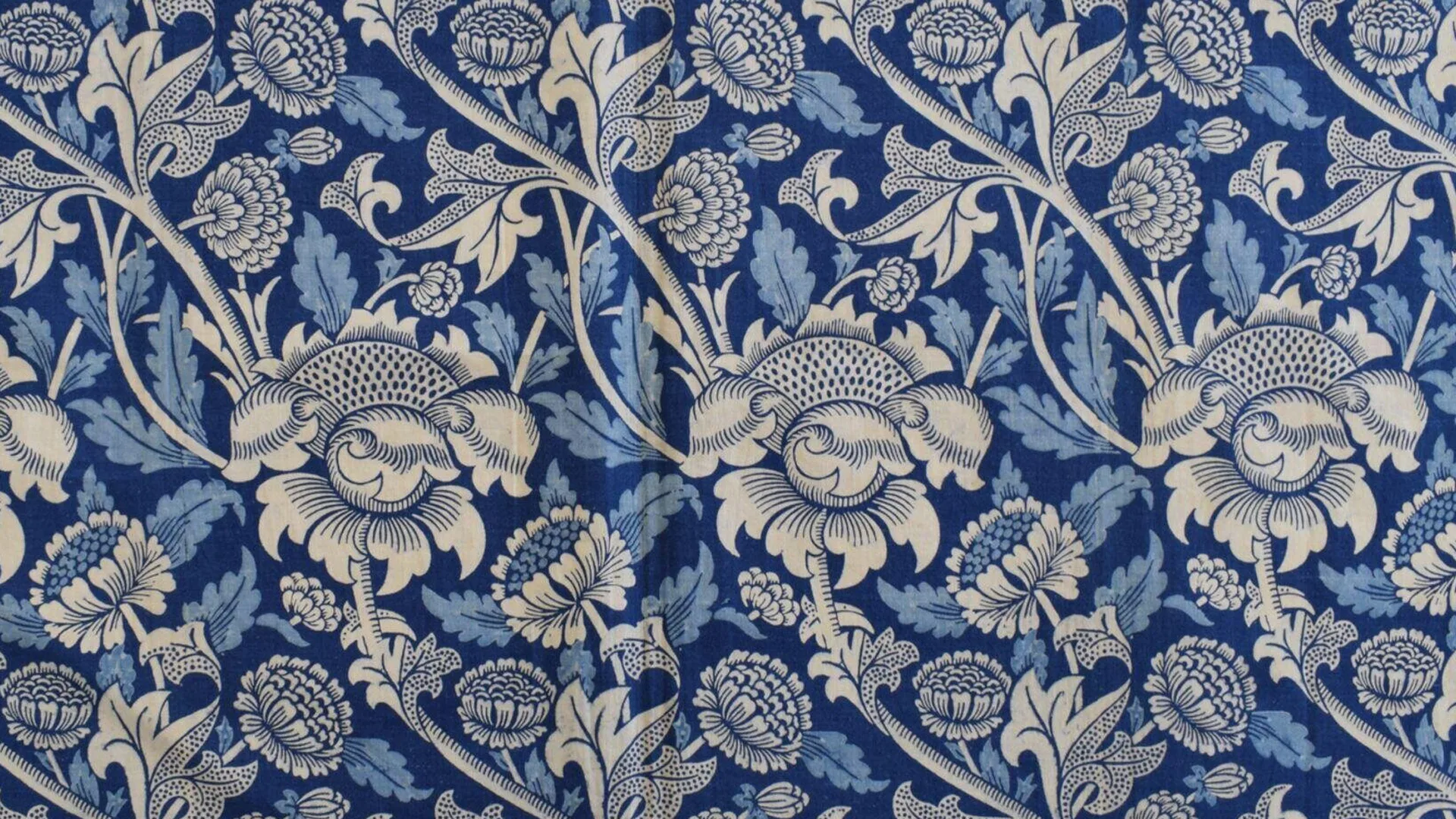 An image of a William Morris pattern called Wey showing blue flowers and leaves.