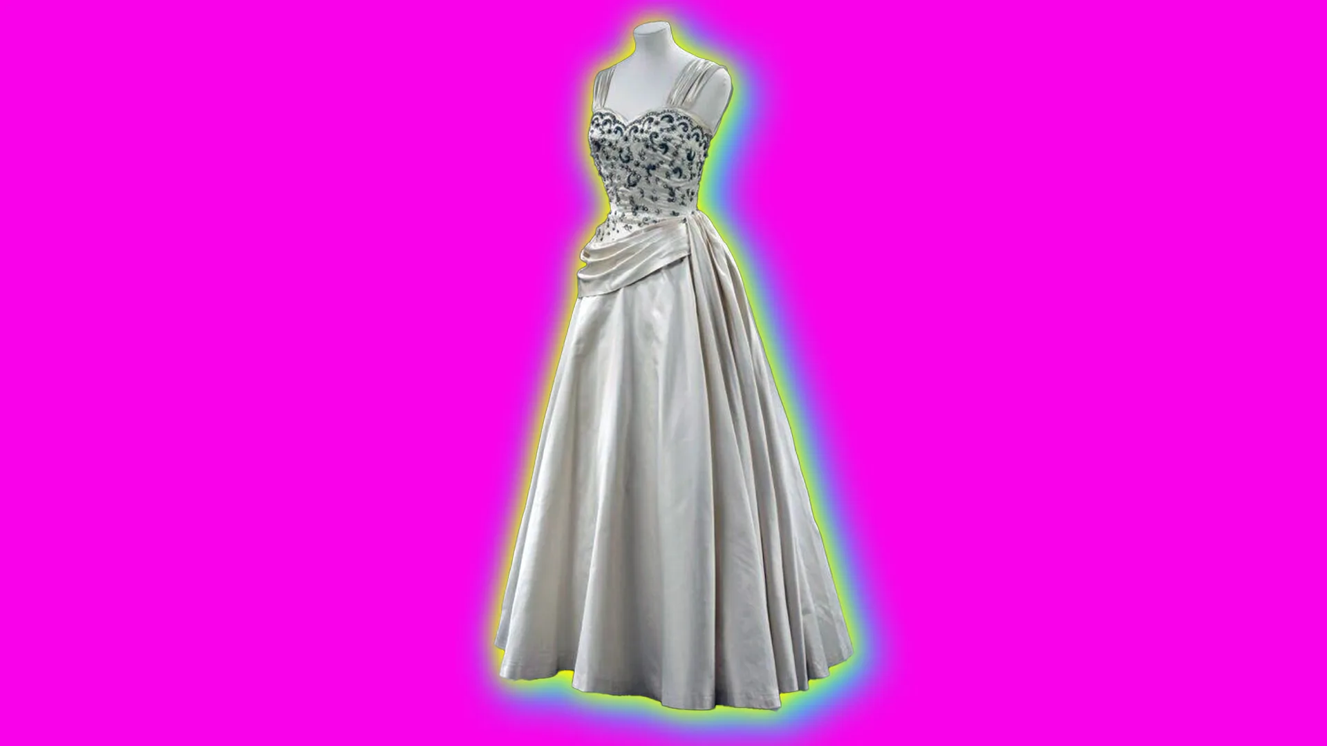 A silk white evening dress with beading on bodice set against a bright pink background