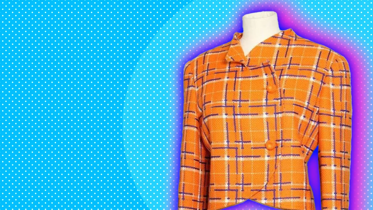 An orange plaid wool jacket with long sleeves on a white mannequin set against a blue dotted background with a pink halo.