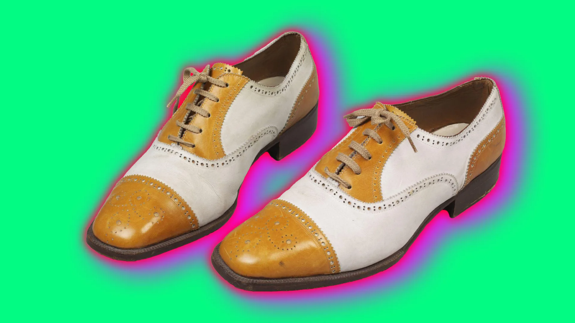 A pair of brown and white brogue shoes with laces set against a mint green background with a pink halo.