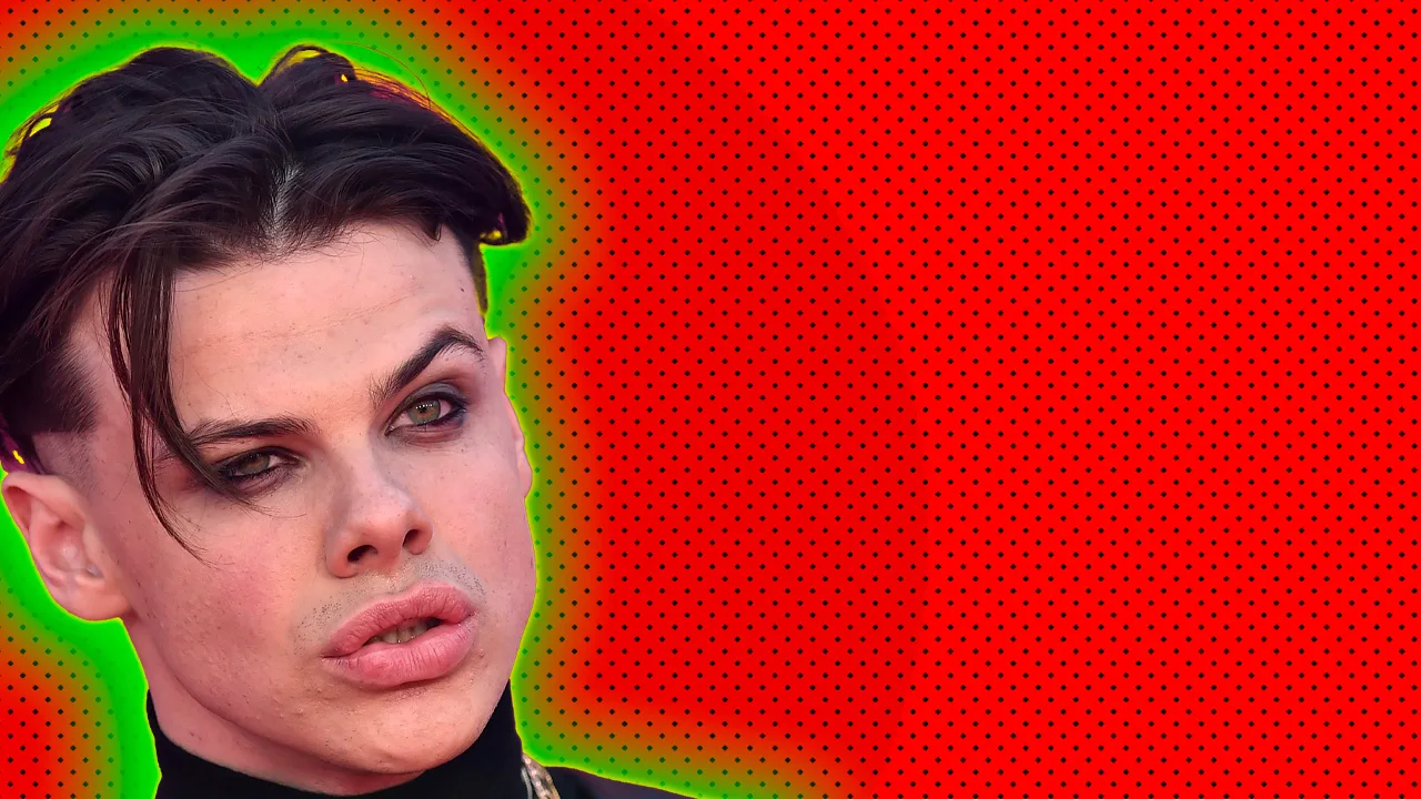 A photo of the singer Yungblud looking to the distance against a red dotted background with a green halo.
