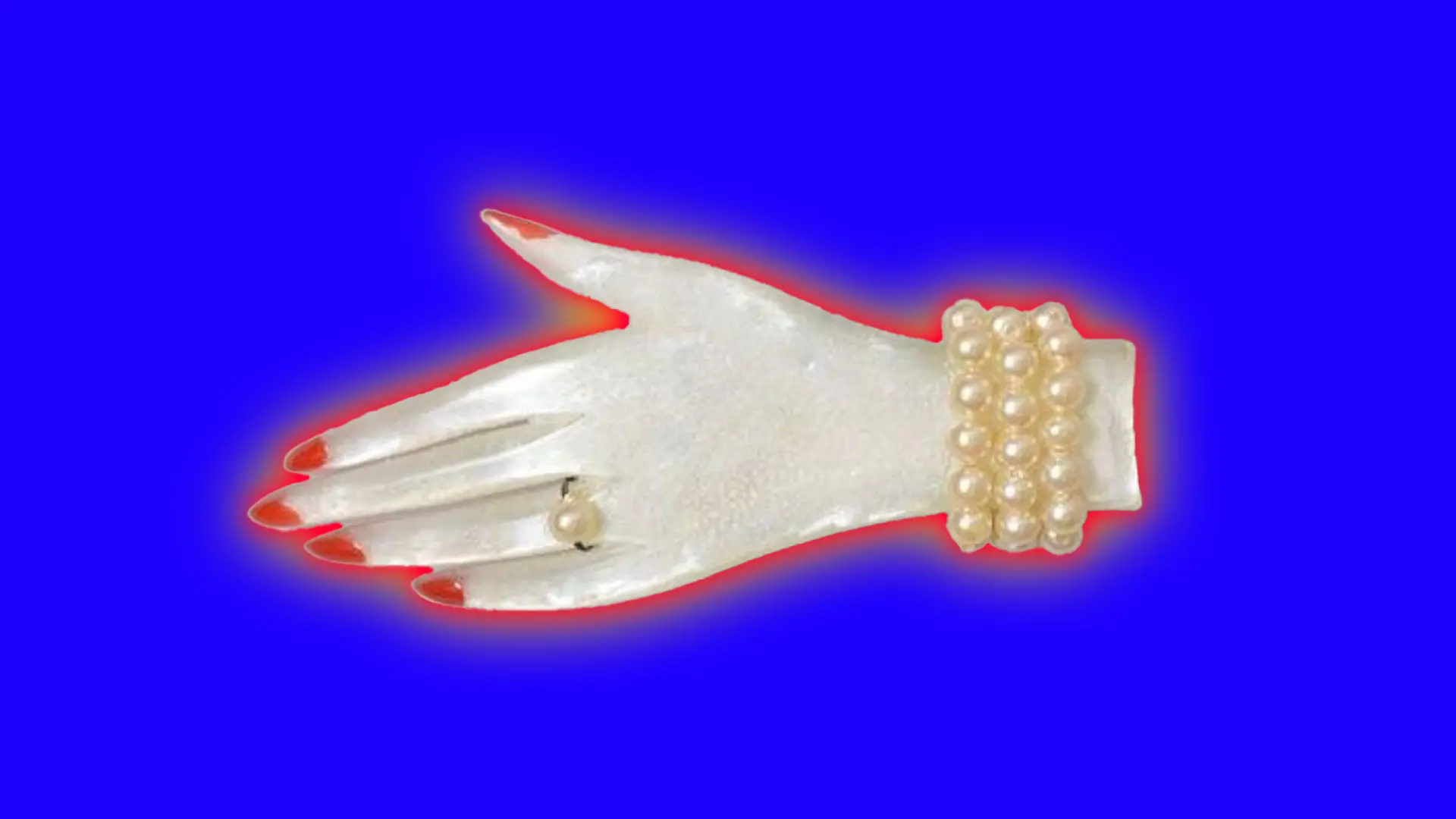 A photo of a brooch in the shape of a hand. The nails are tinted with red and having a ring and bracelet of pearls. It is set against a blue background with a red and yellow halo.