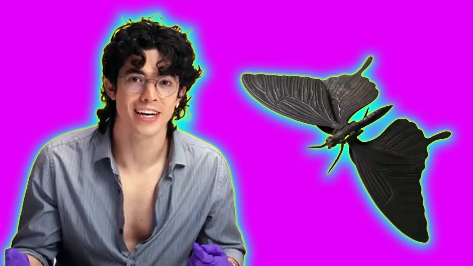 An image of the singer Conan Gray looking face on smiling with a grey shirt and glasses next to a metal sculpture of a moth set against a pink background with a yellow and blue halo.