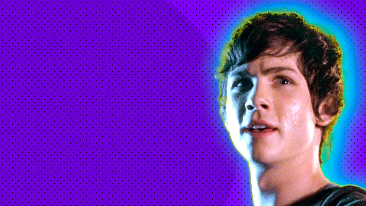 A photo of Percy Jackson looking at something to the right with a blue light on his face set against a purple dotted background with a yellow and blue halo.