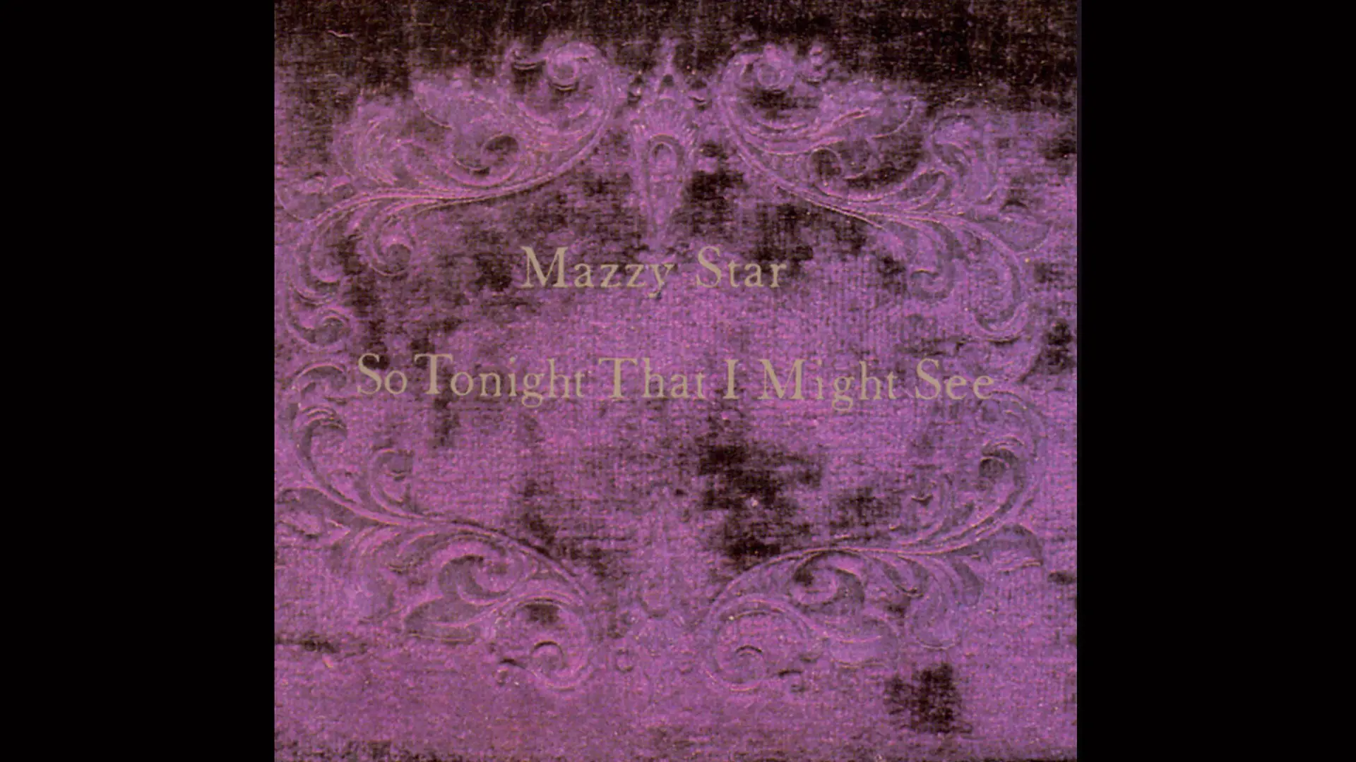 The album cover "So Tonight That I May See" by Mazzy Star showing the title in gold letters with a purple swirly pattern behind against a black background.