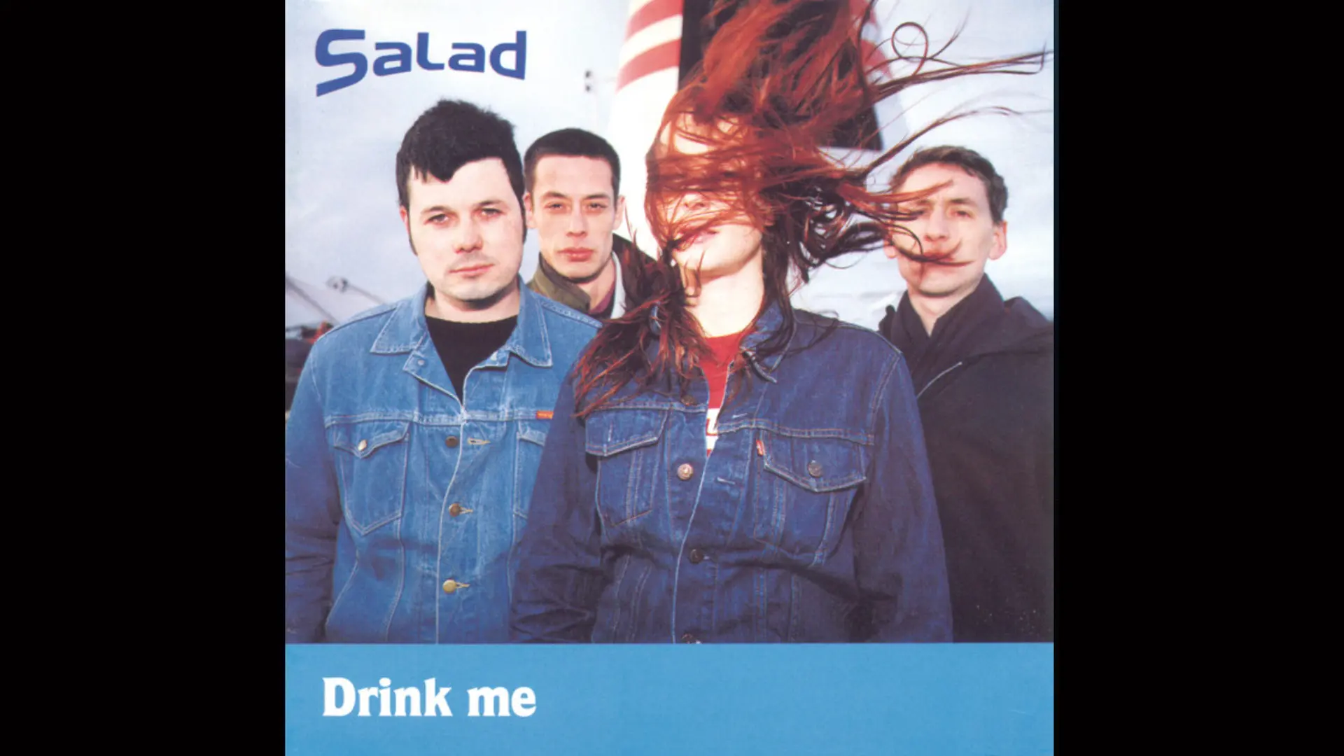The album cover "Drink Me" by the band Salad showing the four members stood together with the the female singer's red hair blowing in her face. The album title is in white text on a blue bar at the bottom.