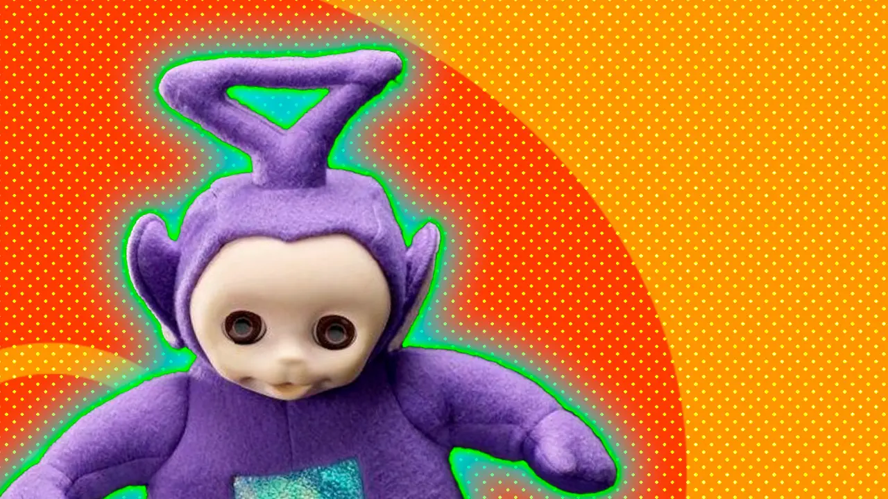 A photo of a purple stuffed toy with a triangular antennae of the Teletubby, Tinky Winky showing him stood up with his arms out against an orange and yellow dotted background with a blue and green halo.