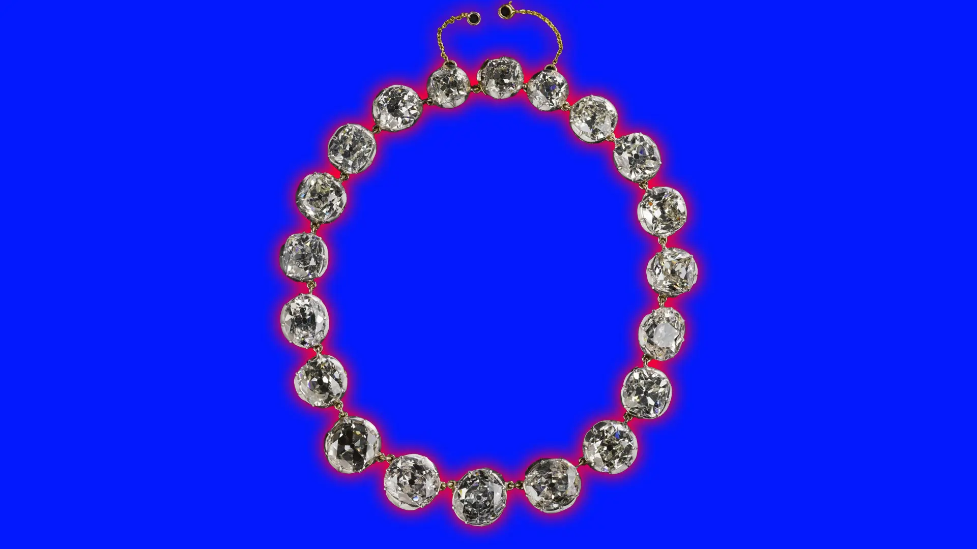 A photo of the Sutherland diamond necklace showing a set of rounded diamonds with a gold clasp set against a blue background with a red halo.