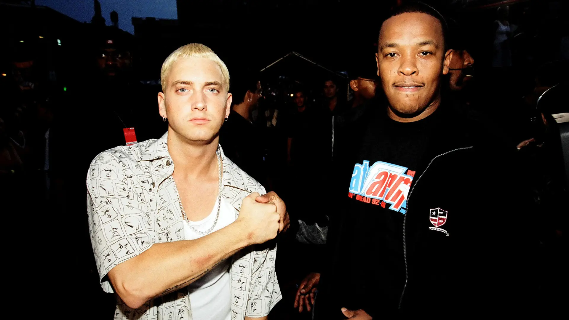 A photo of Eminem and Dr Dre at the MTV music awards 1999 stood together fist-bumping.