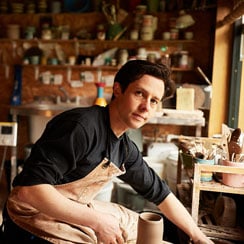 James Sims in his London studio, handthrowing oneof his pieces on a traditional potter's wheel.