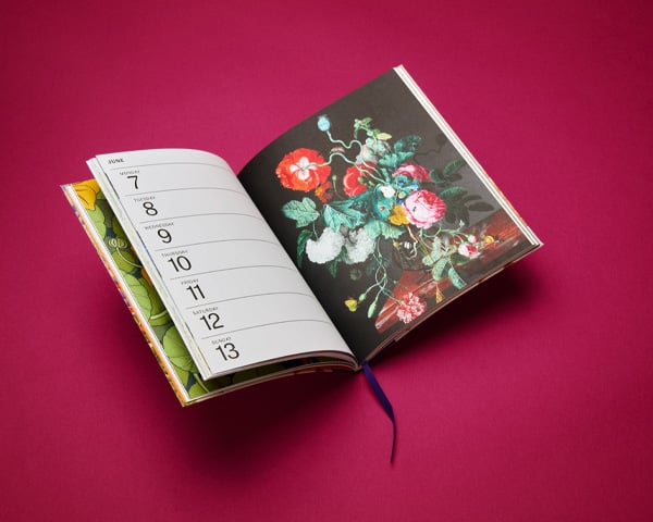 An open desk diary with images from the V&A archive.