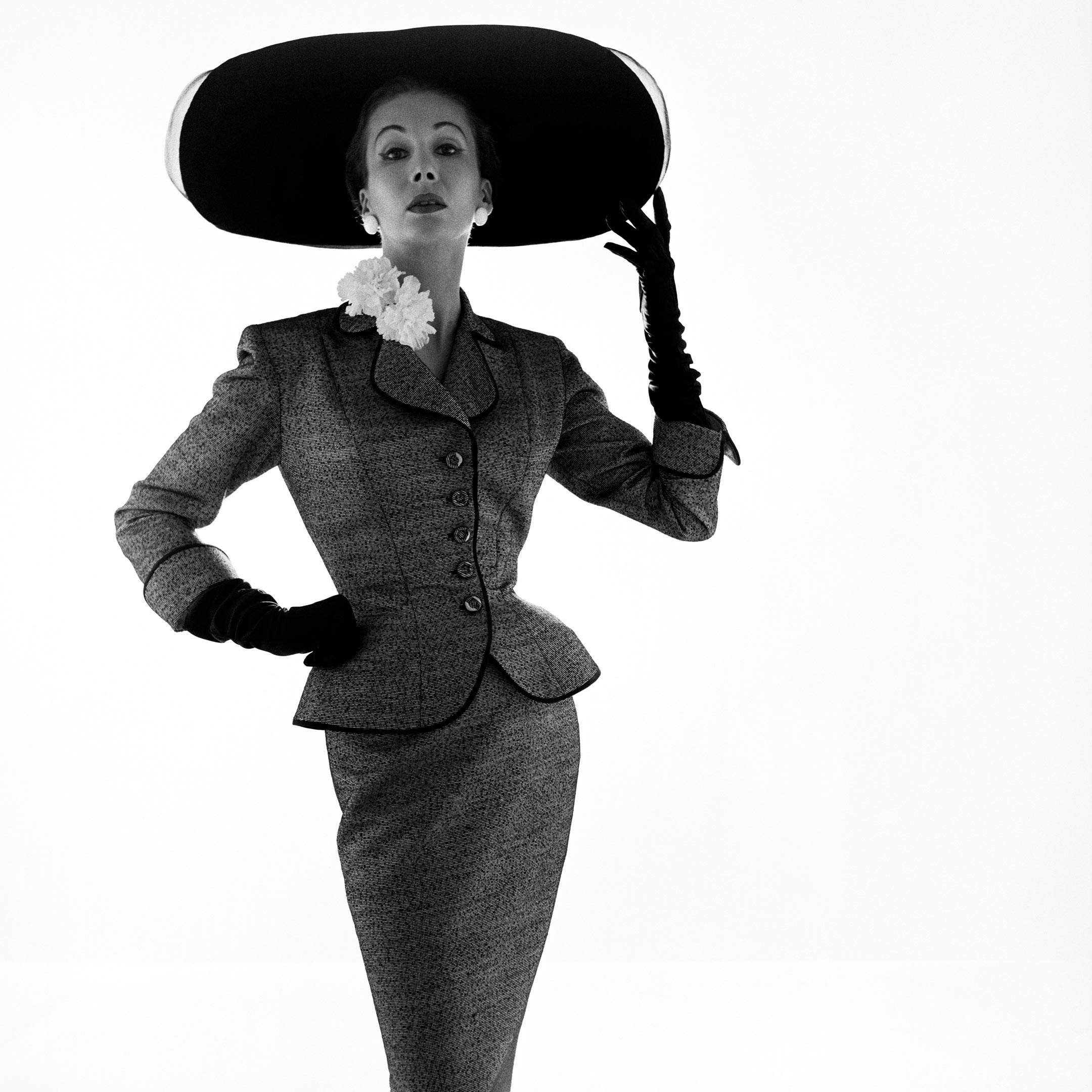 Model posing in wide rimmed hat and fitted suit