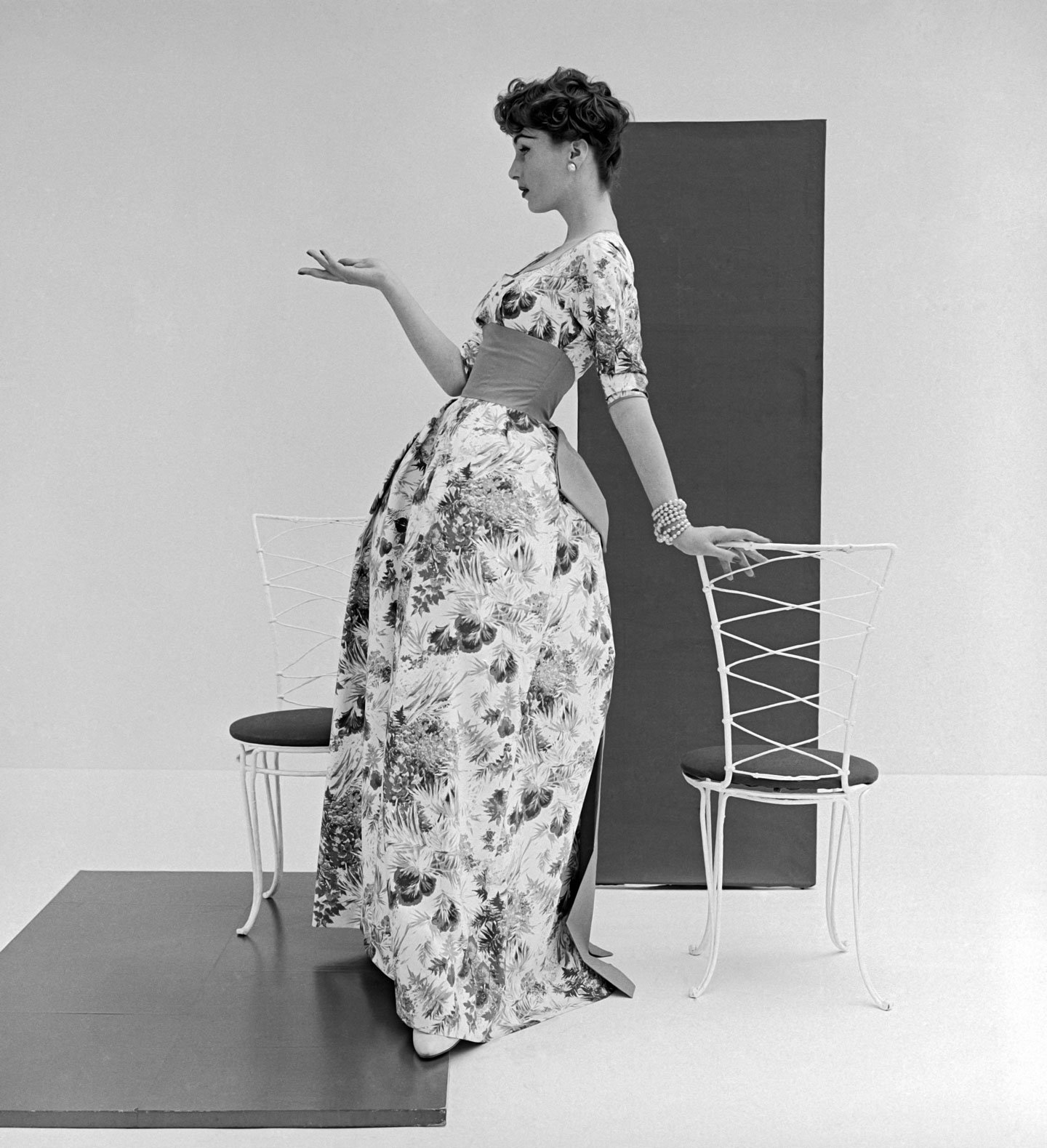 Model posing in long floral evening gown with cummerbund