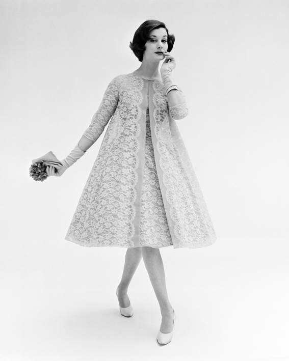 Model posing in short lace swing evening dress