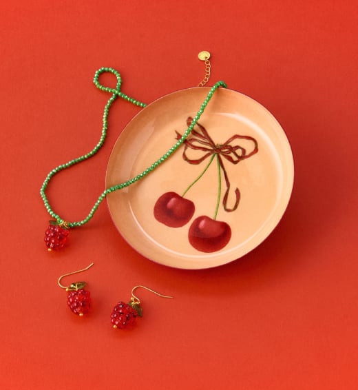 Summer favourites A trinket tray featuring cherries is scattered with jewellery inspired by raspberries