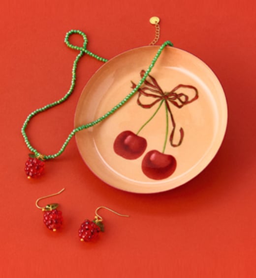 A cherry themed enamel plate and rasberry themed jewellery